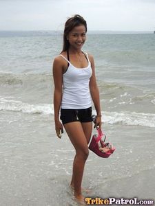 Cute asian teen in short-shorts on the beach.